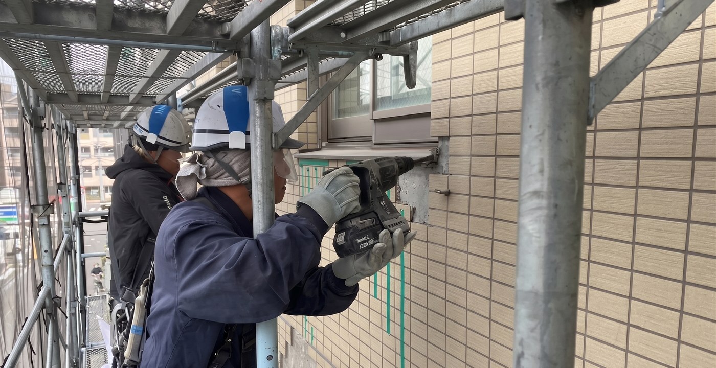 足場上でタイルを点検する職人