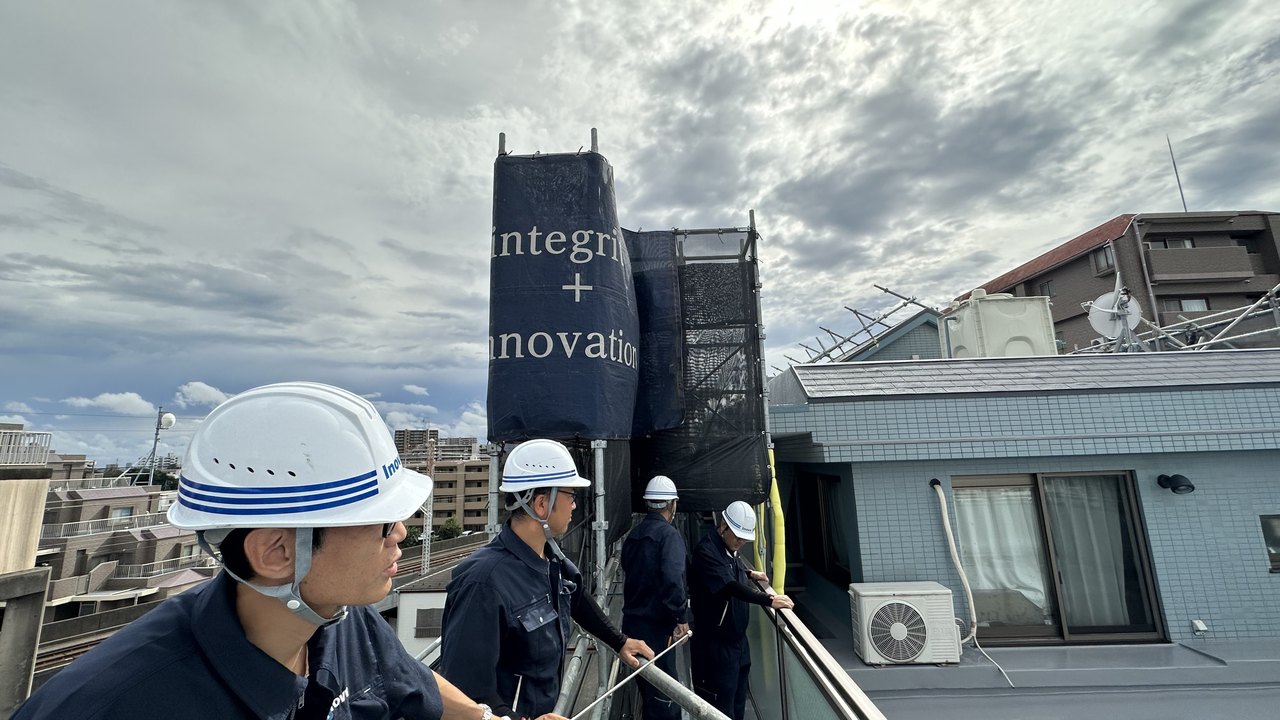 屋上で建物の状況を確認するスタッフ
