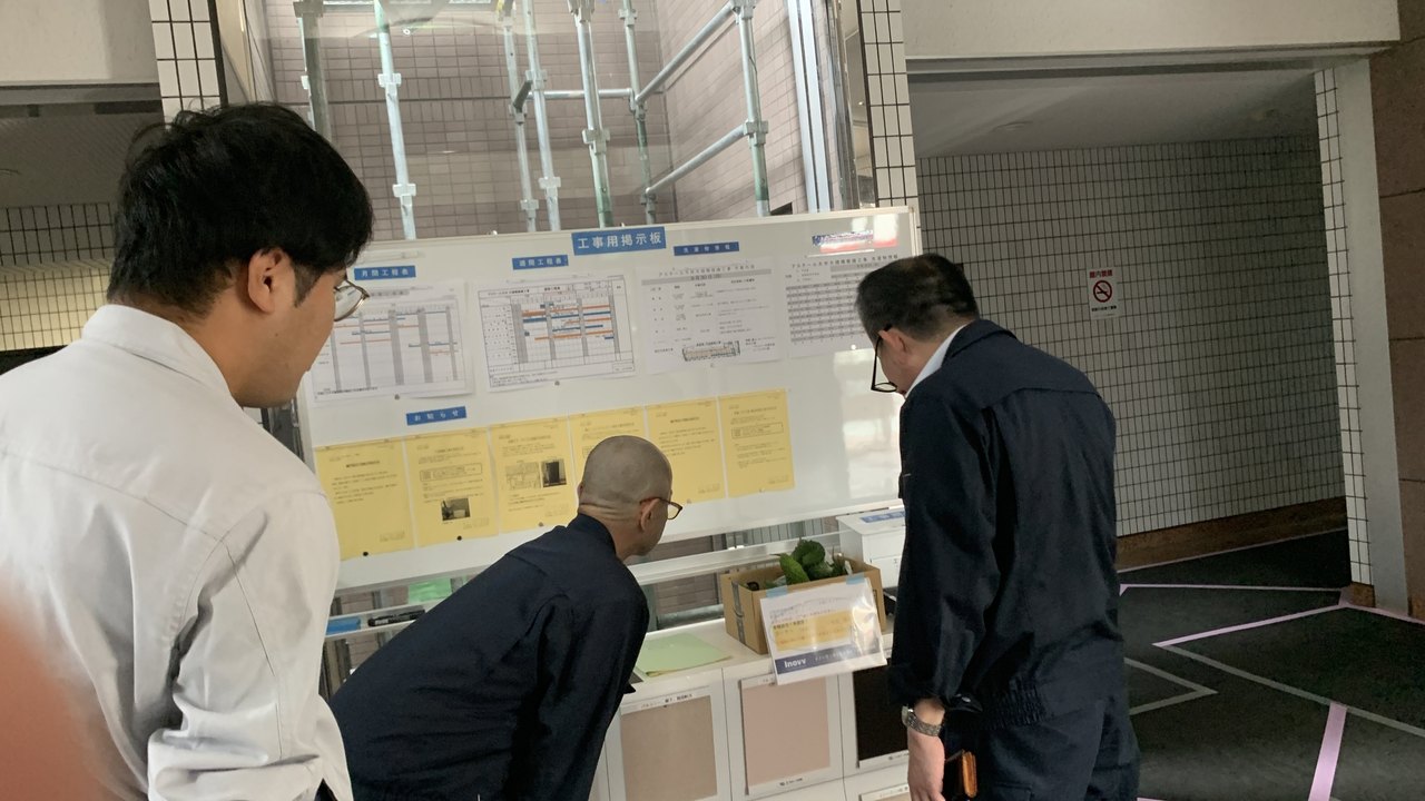 共用部で掲示物を確認するスタッフ